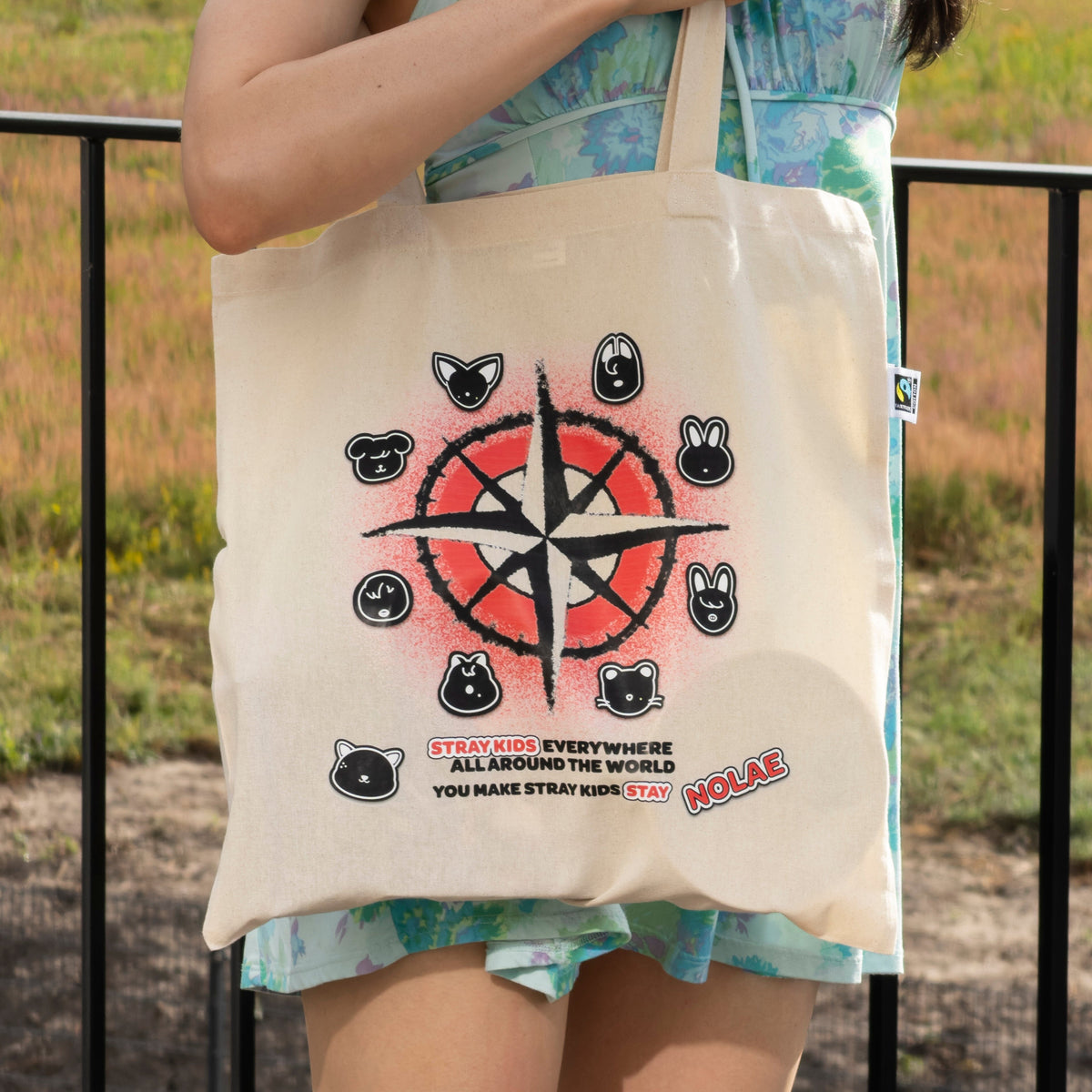 A Nolae canvas tote bag with a Stray Kids print, worn over the shoulder